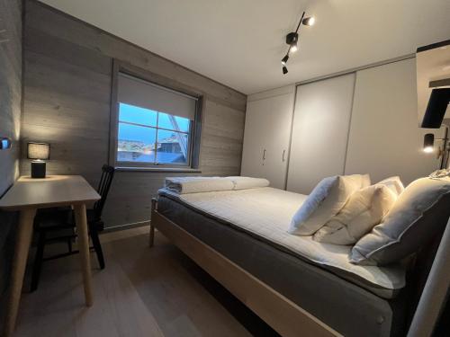 a bedroom with a bed and a table and a window at Funäsdalsporten Funäsdalen in Funäsdalen