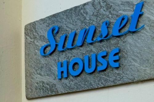 a sign for a smiley house on a wall at 三国サンセットハウス in Tōjimbō
