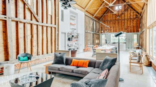 a living room with a couch and a table at Grand Suffolk Barn Conversion in Chelsworth
