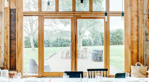 a dining room with a large glass door with a patio at Grand Suffolk Barn Conversion in Chelsworth