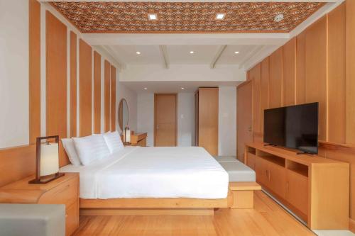 a bedroom with a bed and a flat screen tv at Trân Châu Beach & Resort in Ba Ria