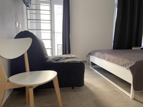 a bedroom with a bed and a chair and a table at Matty's in Olbia