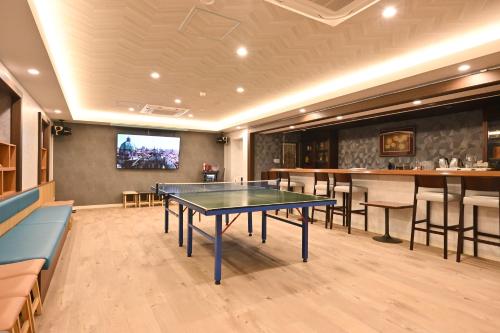 a room with a ping pong table and a bar at Mimatsukan in Shibukawa