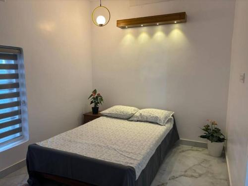 a bedroom with a bed and a light on the wall at Nitara Beach House in Kannur