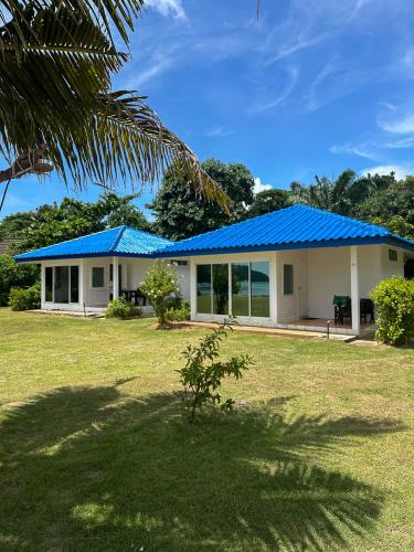 a house with a blue roof and a yard at Sabai Beach Resort in Ko Mak