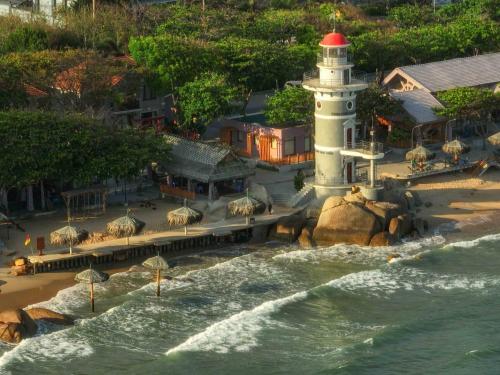 a lighthouse on a beach next to the water at Trân Châu Beach & Resort in Ba Ria