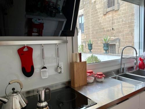 a kitchen counter with a sink and a window at La Dimora dei Pumi Verdi in Manduria