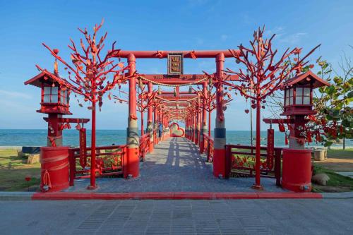a red bridge with trees on the beach at Trân Châu Beach & Resort in Ba Ria