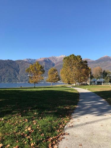 a path in a park with mountains in the background at Casa Nonna Nina in Vercana