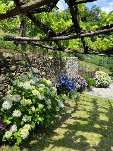 a garden with colorful flowers and a stone wall at Casa Nonna Nina in Vercana