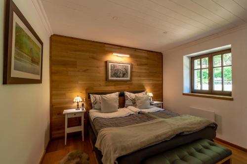 a bedroom with a bed with a wooden wall at Waldhütte in Telekes