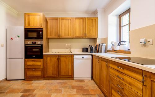a kitchen with wooden cabinets and a white refrigerator at Waldhütte in Telekes