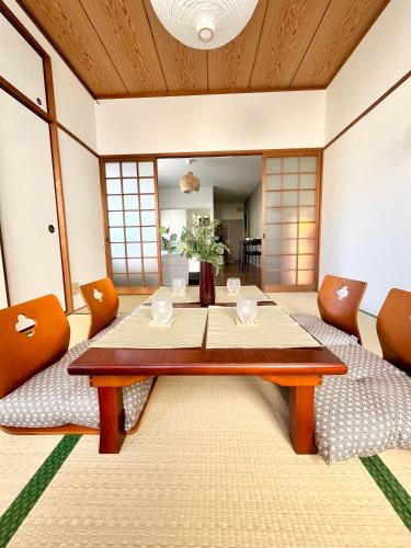 a dining room with a table and chairs at OMOTENASHI STAY OSAKA 41m2 1LDK 十三駅徒歩1分 梅田2分 神戸京都アクセス良好 和室のある家 in Osaka