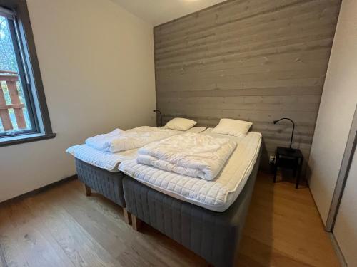 a large bed in a room with a wooden wall at Salmons väg Funäsdalen in Funäsdalen