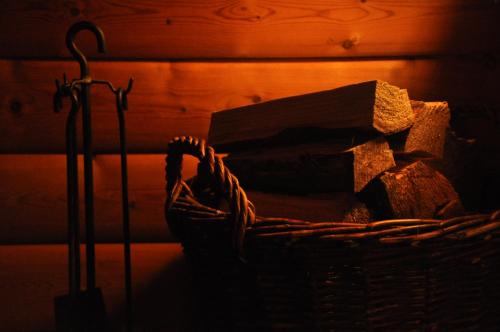 a basket full of logs next to a wall at Log-House Wildernest in Brande