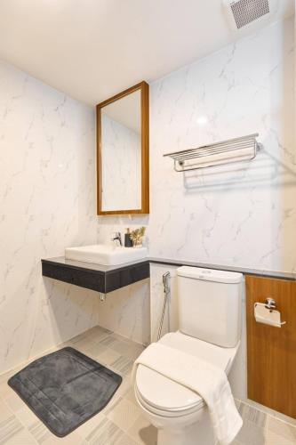 a bathroom with a toilet and a sink at Be Phrasingh Hotel Chiang Mai in Chiang Mai