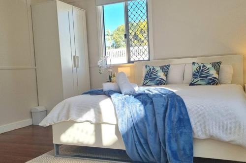a bedroom with a bed with a blue blanket on it at The Heavenly Haven in Brisbane