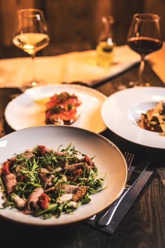 a table with plates of food and glasses of wine at OTTON-Charzykowy Bed&Restaurant in Chojnice