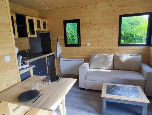 a living room with a couch and a table at Au Pied du Merisier in Signy-lʼAbbaye