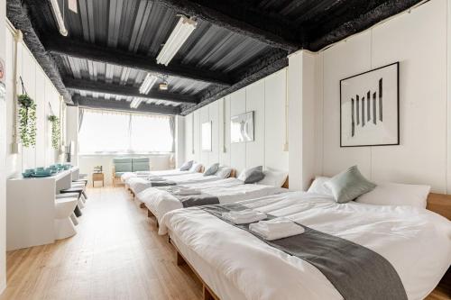 a row of white beds in a room with ceilings at DS Dotonbori II 3F DD3 in Osaka