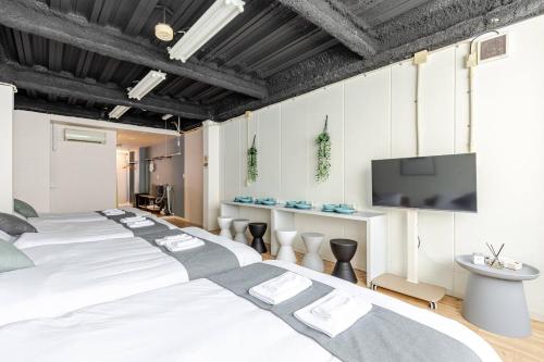 a bedroom with a large white bed and a flat screen tv at DS Dotonbori II 3F DD3 in Osaka