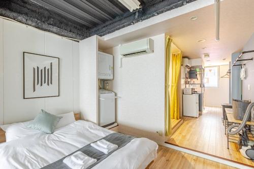 a small bedroom with a bed and a kitchen at DS Dotonbori II 3F DD3 in Osaka
