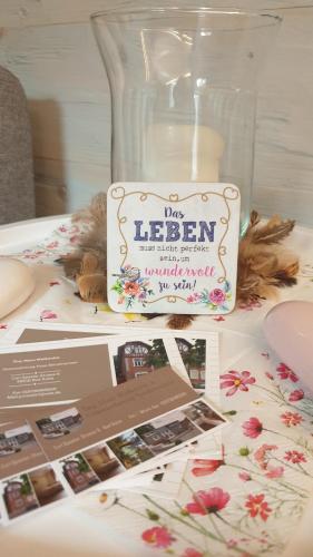 a sign sitting on top of a table with a vase at Tinyhaus Wolkenlos Familie Hamdorf in Bad Sulza