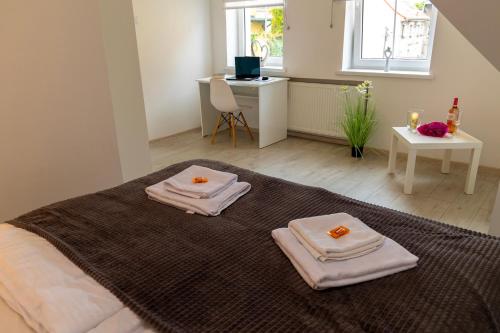 a bedroom with a bed with two towels on it at Apartamenty Zieleniec-Julia 3 in Duszniki Zdrój