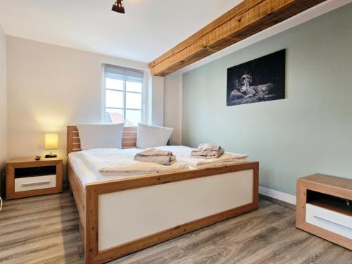 a bedroom with a bed with a wooden frame at Moritz Apartments - Apartment Pfarrgasse 11 - in Küllstedt