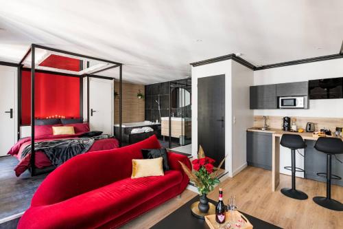 un salon avec un canapé rouge et une chambre dans l'établissement Suite Jean Jaurès - Love Room, à Saint Etienne
