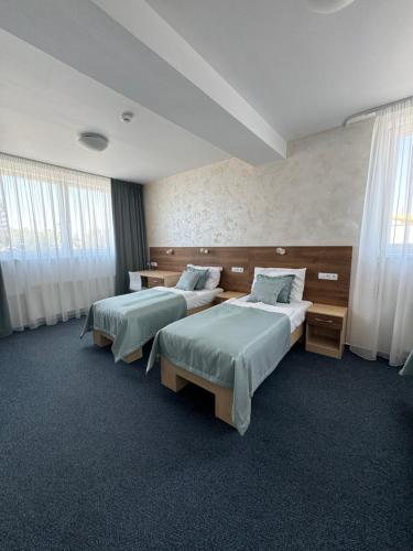 a hotel room with two beds and windows at Sport hotel Sletiště in Kladno