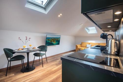 a kitchen and living room with a table and chairs at D&A Amphitheatre Premium Apartments with FREE Parking in Pula
