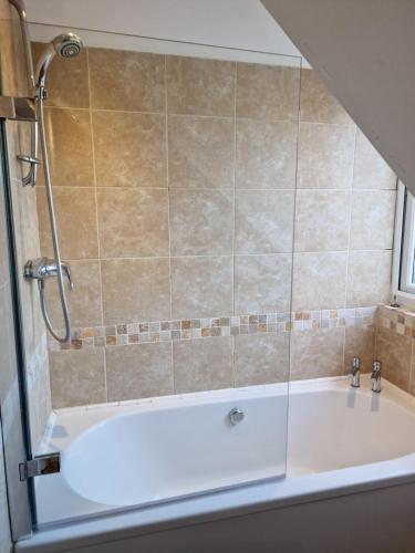 a bath tub in a bathroom with a shower at Large 4-bed house for up to 7 guests w 2x parking in Oxford