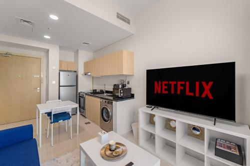 sala de estar con TV y cocina en Modern 1 Bed with Sofa Bed and Access to Pool and Gym, en Dubái
