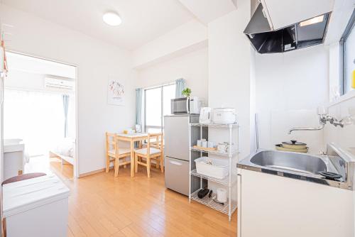 a white kitchen with a sink and a table at mori house西が丘 in Tokyo
