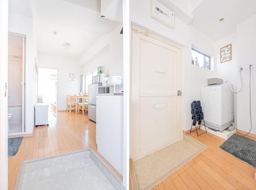 a kitchen and a living room with white appliances at mori house西が丘 in Tokyo