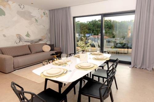 a dining room with a white table and chairs at Villa Barovic - Delux Apartment in Mlini