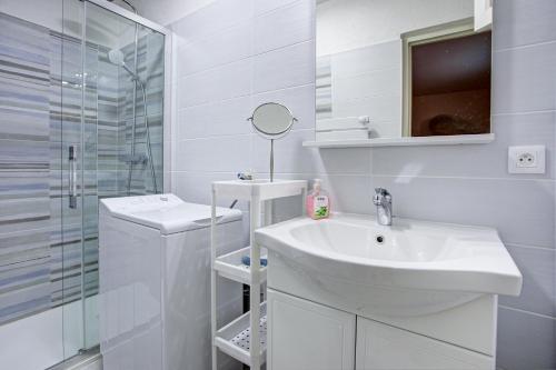 une salle de bain blanche avec un lavabo et une douche dans l'établissement Mirande RDC - Appt à 1km de la plage avec jardin, à Port-Vendres