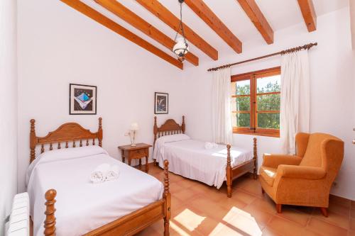 a bedroom with two beds and a chair and a window at Villa Pedra Vista by Sealand Villas in El Port