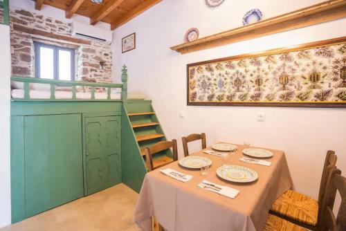a dining room with a table and a green cabinet at Amarantos-Traditional Village House-Apollona in Apóllona