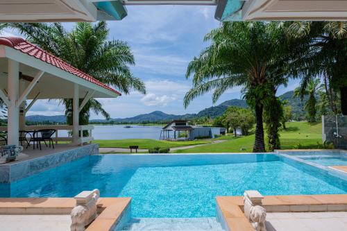 a swimming pool with a view of the water at Coco Golf Villa in Ban Huai Luk (1)