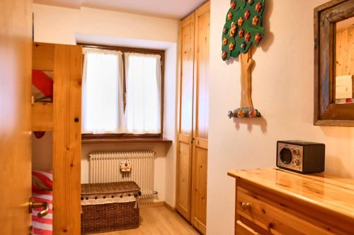 een kleine kamer met een magnetron en een kerstboom aan de muur bij Villa Antermont in Canazei