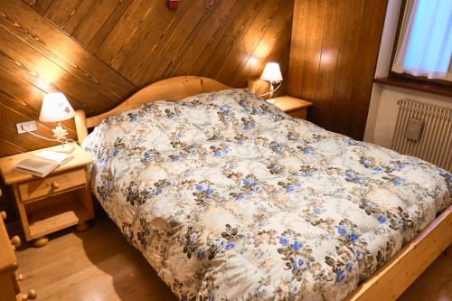 een slaapkamer met een bed met blauwe bloemen erop bij Villa Antermont in Canazei