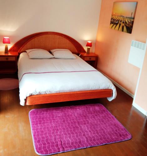 - une chambre avec un grand lit et un tapis violet dans l'établissement Appartement T3 GASCOGNE, à Bahus-Soubiran