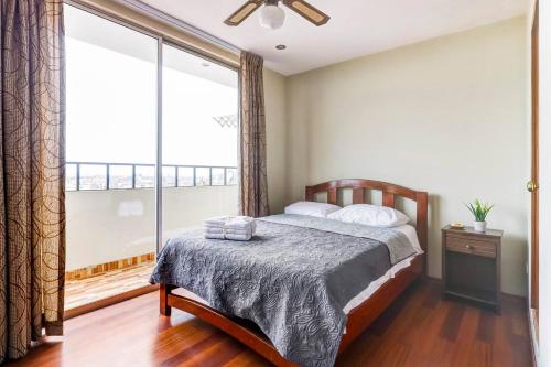 a bedroom with a bed and a large window at Apartamentos Estela en Alameda colonial - 5km Aeropuerto Jorge Chávez in Lima