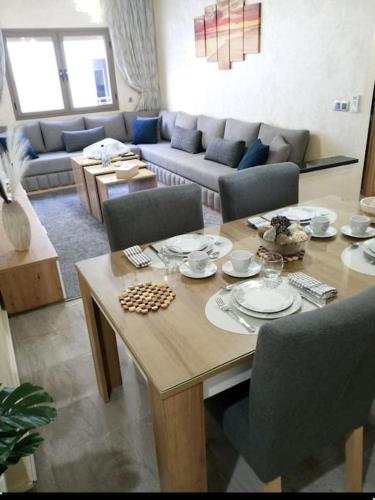 a living room with a table and a couch at Home Lesieur 16 in El Jadida
