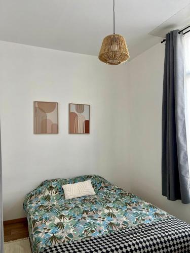 - une chambre avec un lit et une lampe pendant dans l'établissement Agréable T2, proche plage G, à Rosendaël