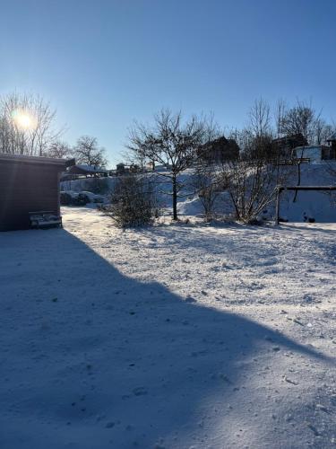 a shadow of a building in a snow covered field at Apartmány U Šťastných in Cerny Dul
