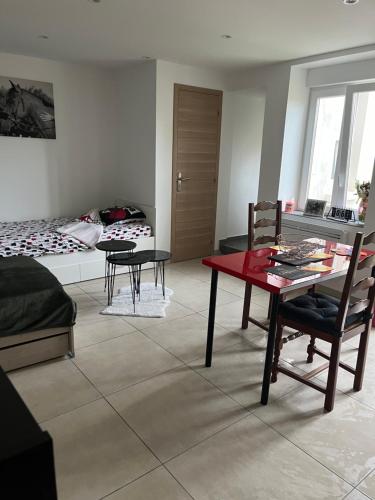 - un salon avec une table et des chaises rouges dans l'établissement Le petit nouveau avec Jardin, à Pont-à-Mousson