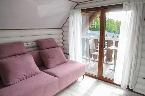 a purple couch in a room with a balcony at База відпочинку Forest Stream in Svalyava
